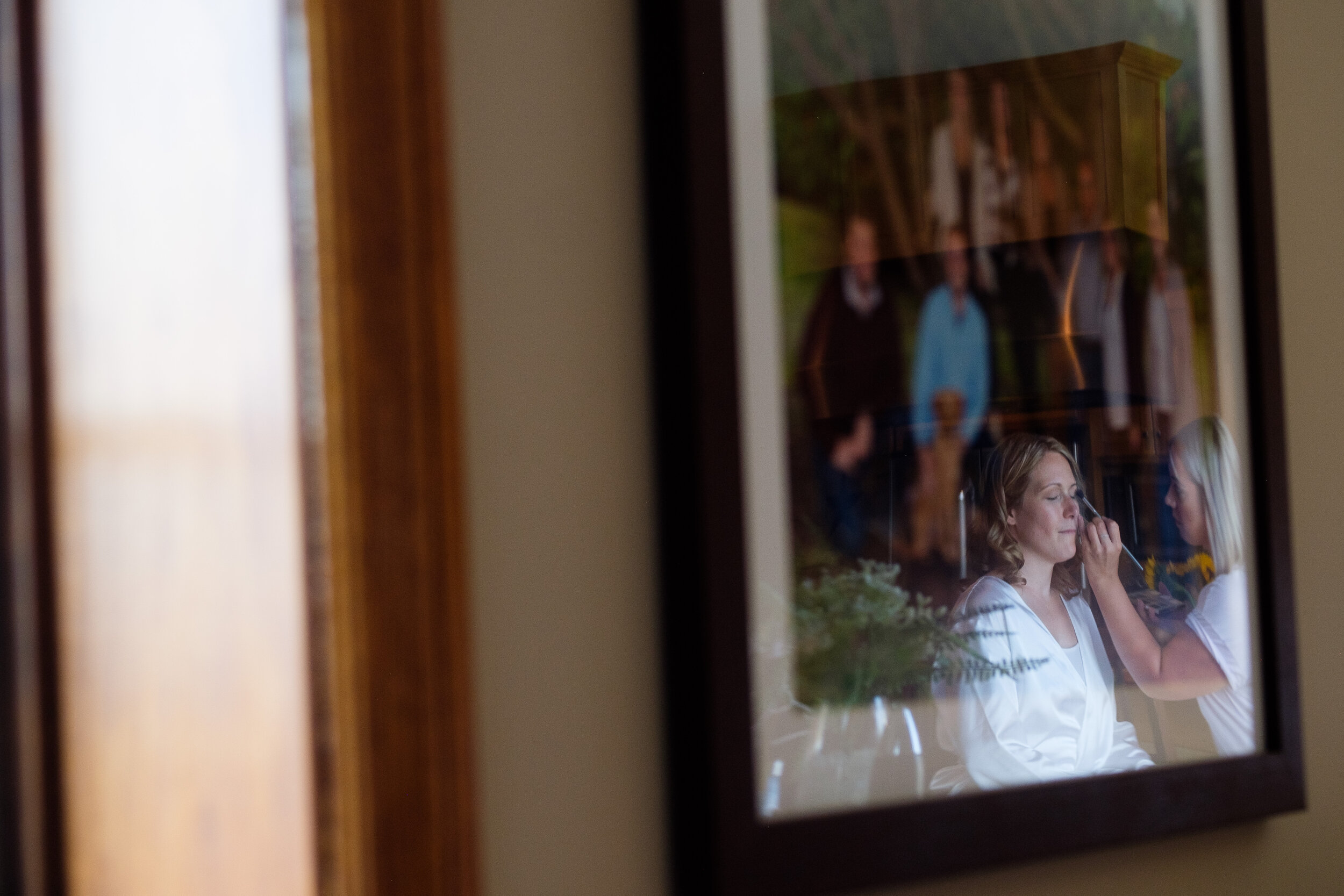  A reflection photograph as Amanda has her hair and make up done at her parents home in Exeter, Ontario before her wedding at the Hessenland Inn by Ontario Wedding Photographer Scott Williams. 