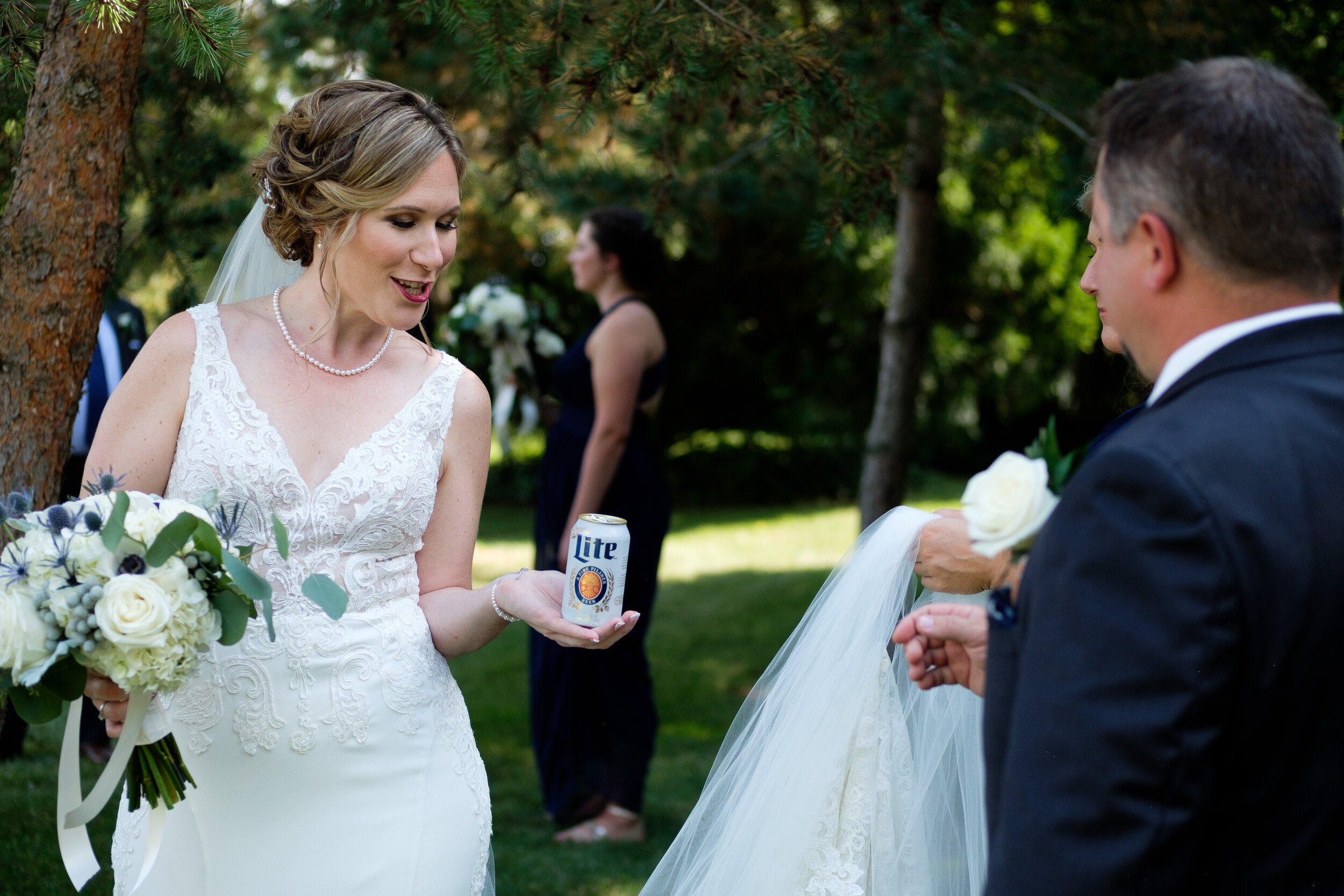   Amanda offers Chad a beer after their first look at her parents home in Exeter, Ontario before her wedding at the Hessenland Inn by Ontario Wedding Photographer Scott Williams. 