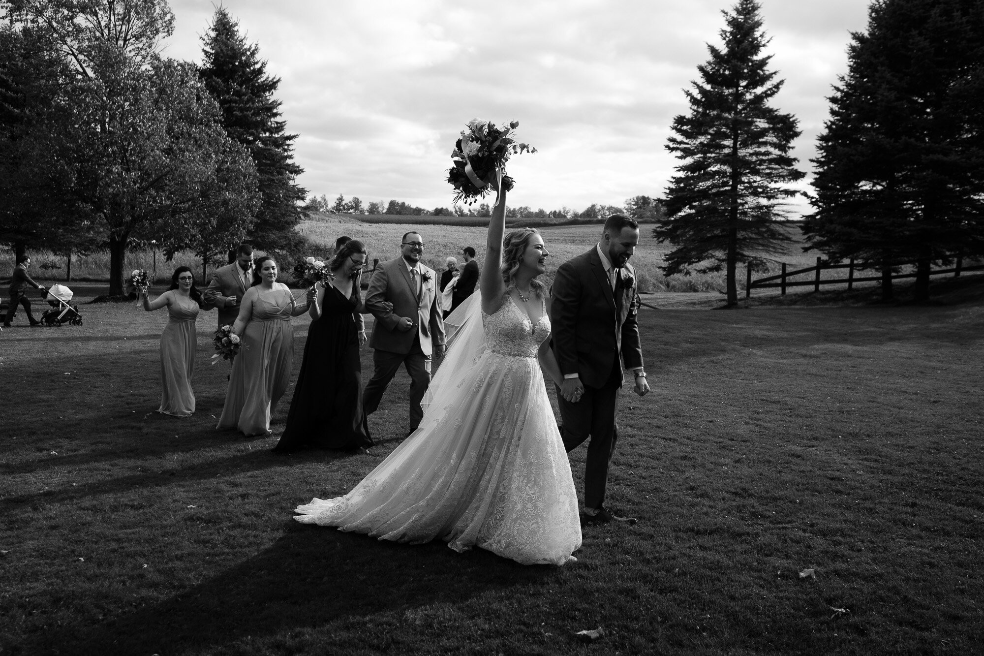  The bride and groom walk back up the aisle during the outdoor wedding ceremony at the Three Bridges event centre located outside of Waterloo, Ontario. Photograph by Toronto wedding photographer Scott Williams. 