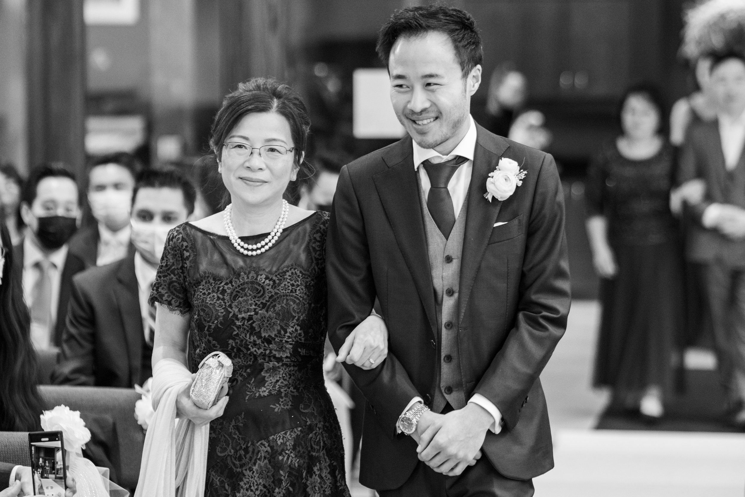  A candid wedding photograph of Jarvis walking his mom down the wedding aisle at Lawrence Park Community Church  before their wedding reception later at Graydon Hall in Toronto, Ontario.  Photograph by Toronto Wedding Photographer Scott Williams.  