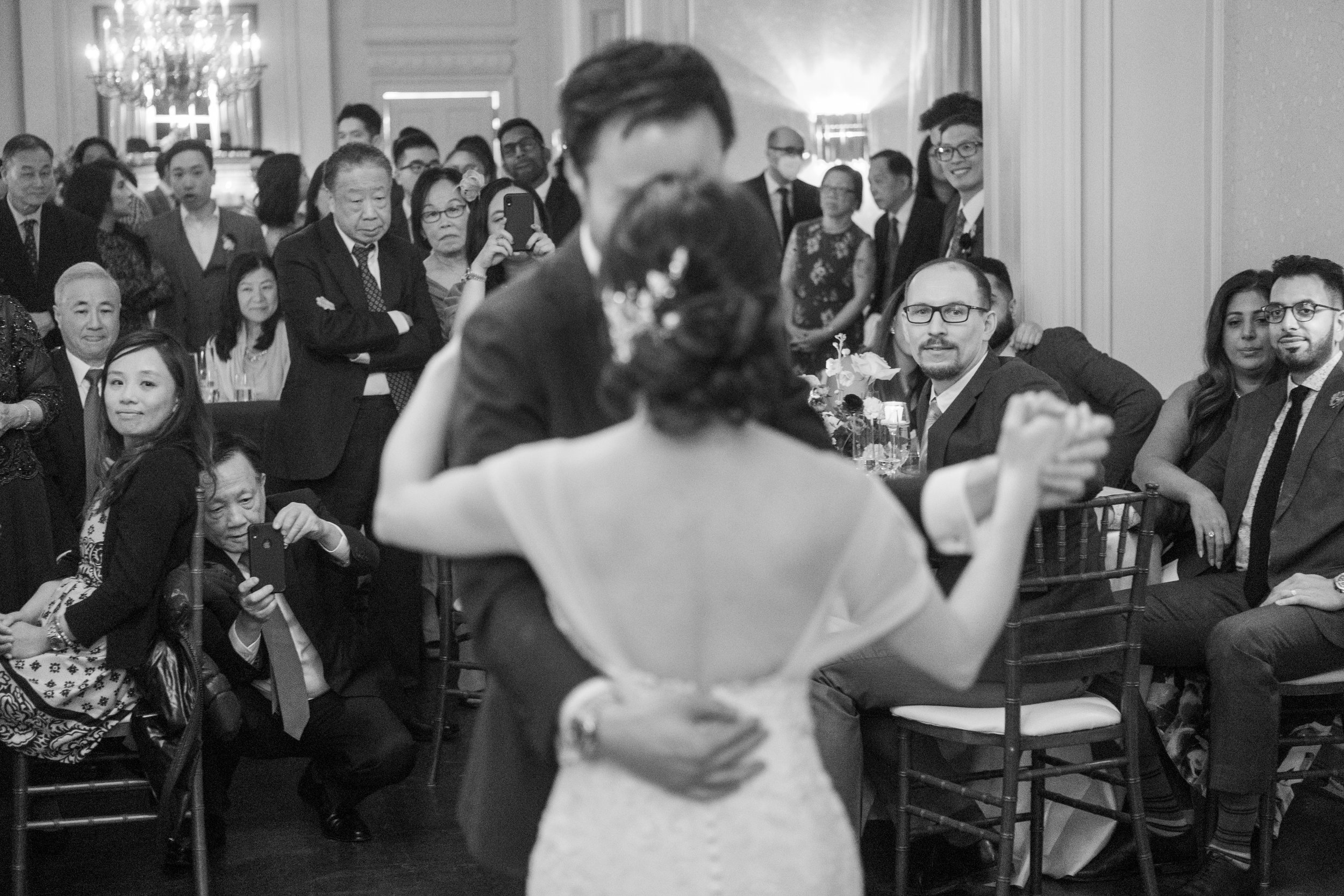  A candid wedding photograph of Jennifer + Jarvis during their first dance during their wedding reception later at Graydon Hall in Toronto, Ontario.  Photograph by Toronto Wedding Photographer Scott Williams.  