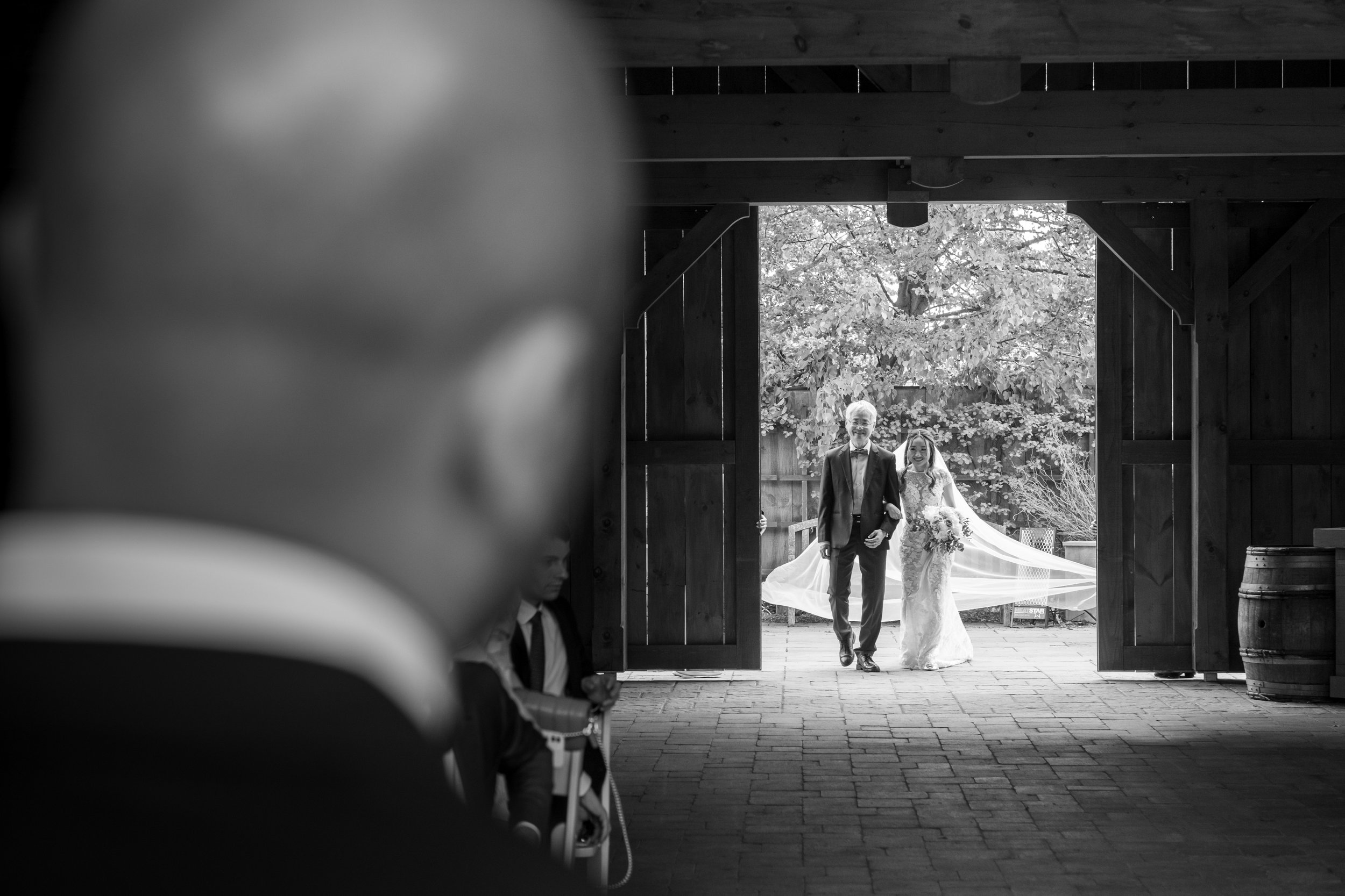  A black and white candid wedding photograph as the bride starts her walk down the aisle during the ceremony from Tiffany + Zoubin’s wedding at Langdon Hall by Toronto Wedding Photographer Scott Williams (www.scottwilliamsphotographer.com) 