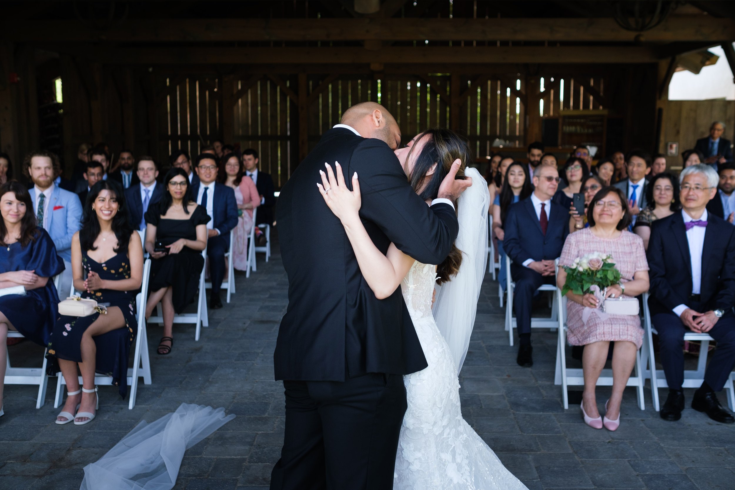  A colour candid wedding photograph of the couple kissing during he ceremony from Tiffany + Zoubin’s wedding at Langdon Hall by Toronto Wedding Photographer Scott Williams  