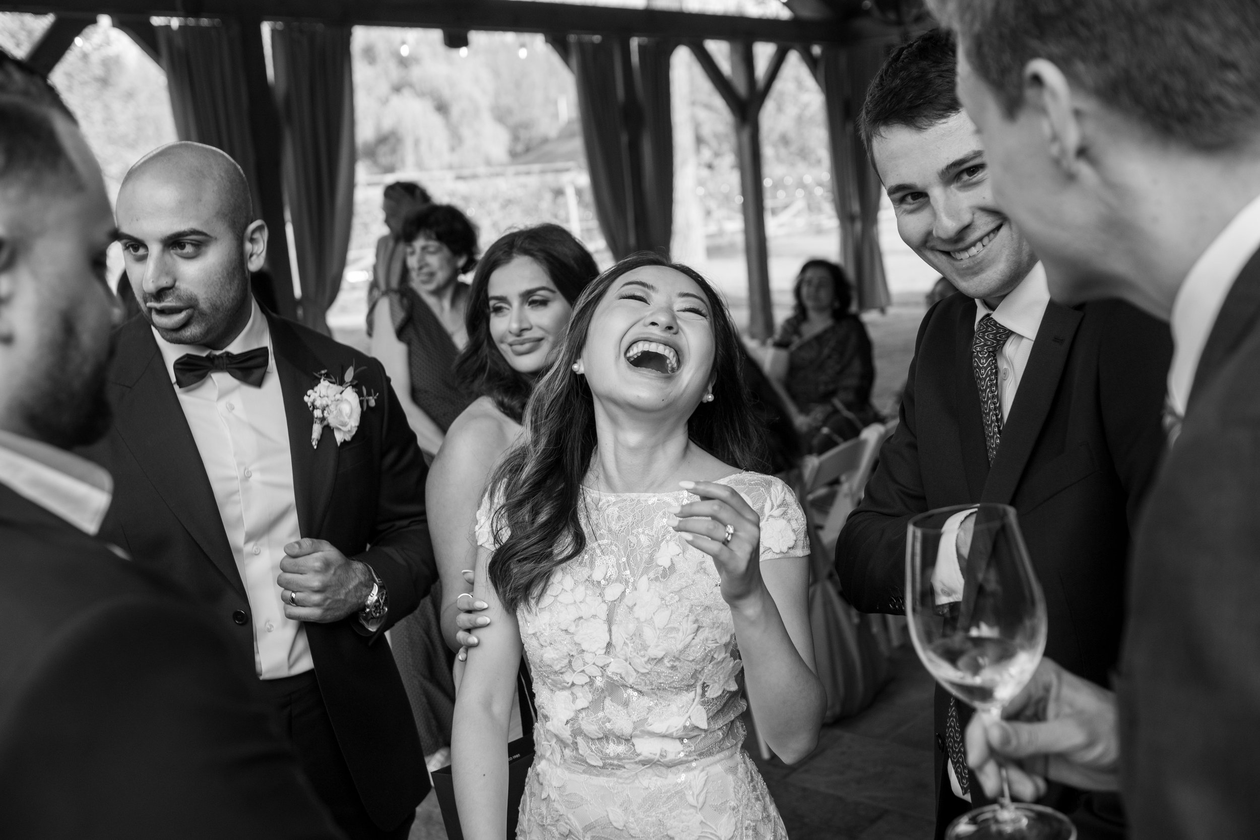  A black and white candid wedding photograph of Tiffany laughing during cocktail hour Tiffany + Zoubin’s wedding at Langdon Hall by Toronto Wedding Photographer Scott Williams  