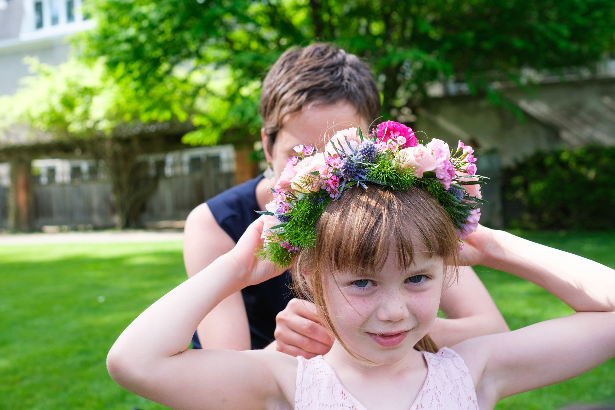  A colour candid wedding photograph of one of Greg and Damon’s flower girls as she has her floral crown adjusted on the grounds of Langdon Hall before the wedding ceremony.  Photograph by Toronto wedding photographer Scott Williams (www.scottwilliams