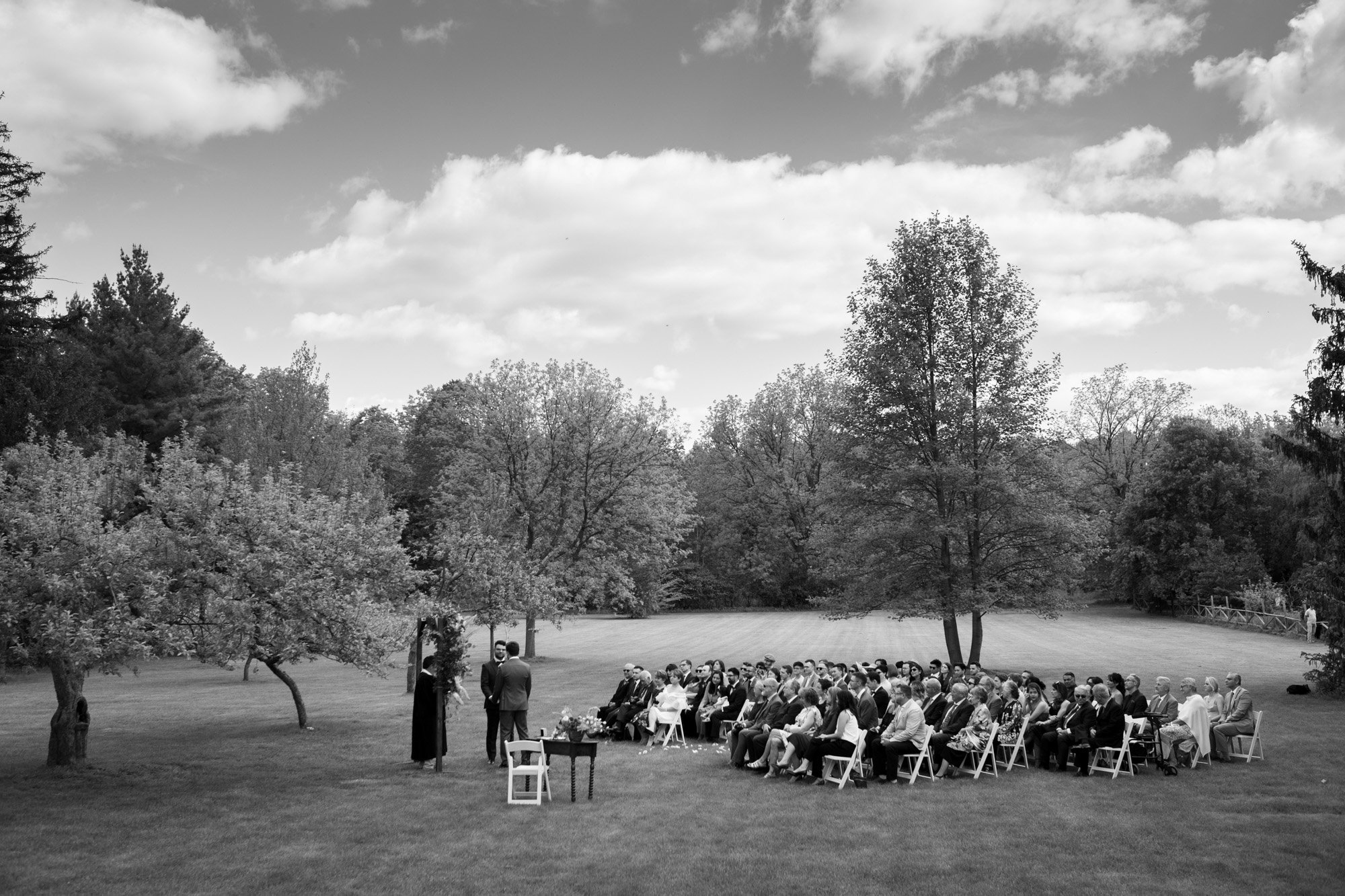  A black and white candid wedding photograph of Greg and Damon’s wedding ceremony at the Orchard lawn on the grounds of Langdon Hall   Photograph by Toronto wedding photographer Scott Williams (www.scottwilliamsphotographer.com) 