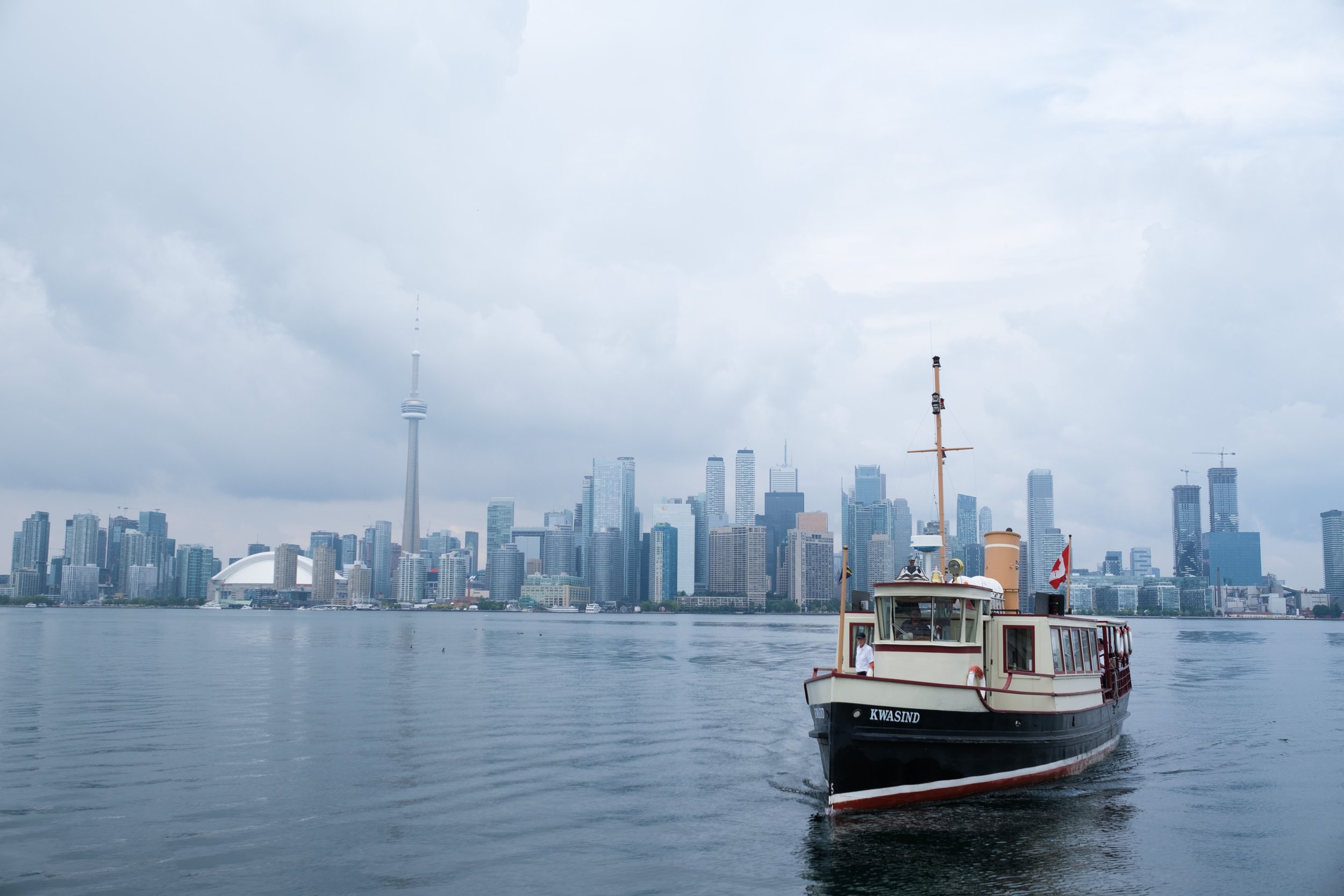  A colour detail wedding photograph of guest arriving in the club ferry  before Rocio and Geoff’s wedding at the Royal Canadian Yacht Club by Toronto wedding photographer Scott Williams  