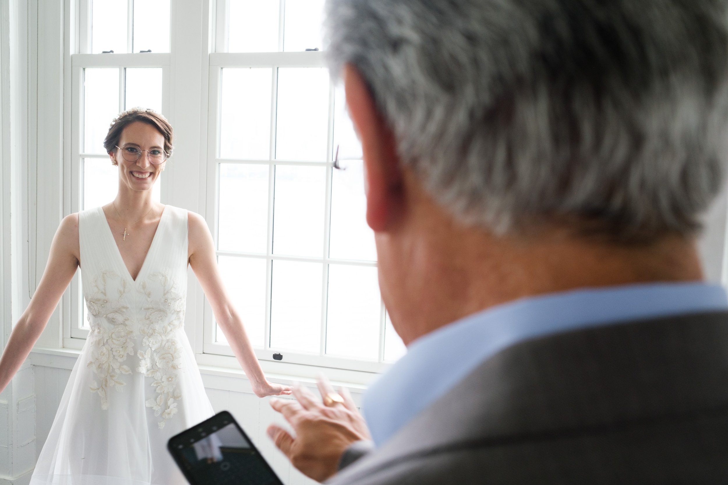  A colour wedding candid  photograph of Rocio’s father seeing in her dress for the first time before her wedding at the Royal Canadian Yacht Club by Toronto wedding photographer Scott Williams  