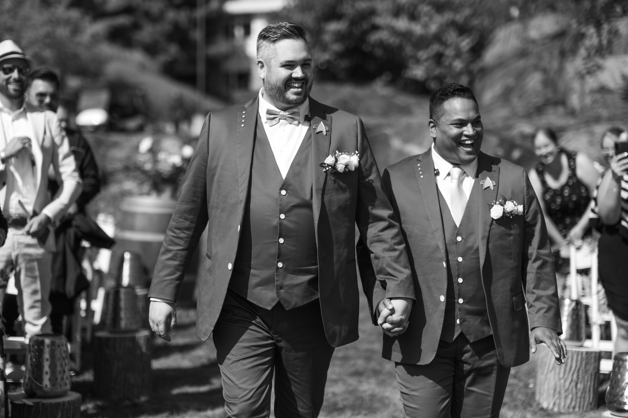  A black and white candid wedding photograph of Bryan + Adam walking down the aisle during their  outdoor wedding cermony  at the JW Marriot The Rosseau in Muskoka by Toronto wedding photographer Scott Williams (www.scottwilliamsphotographer.com) 