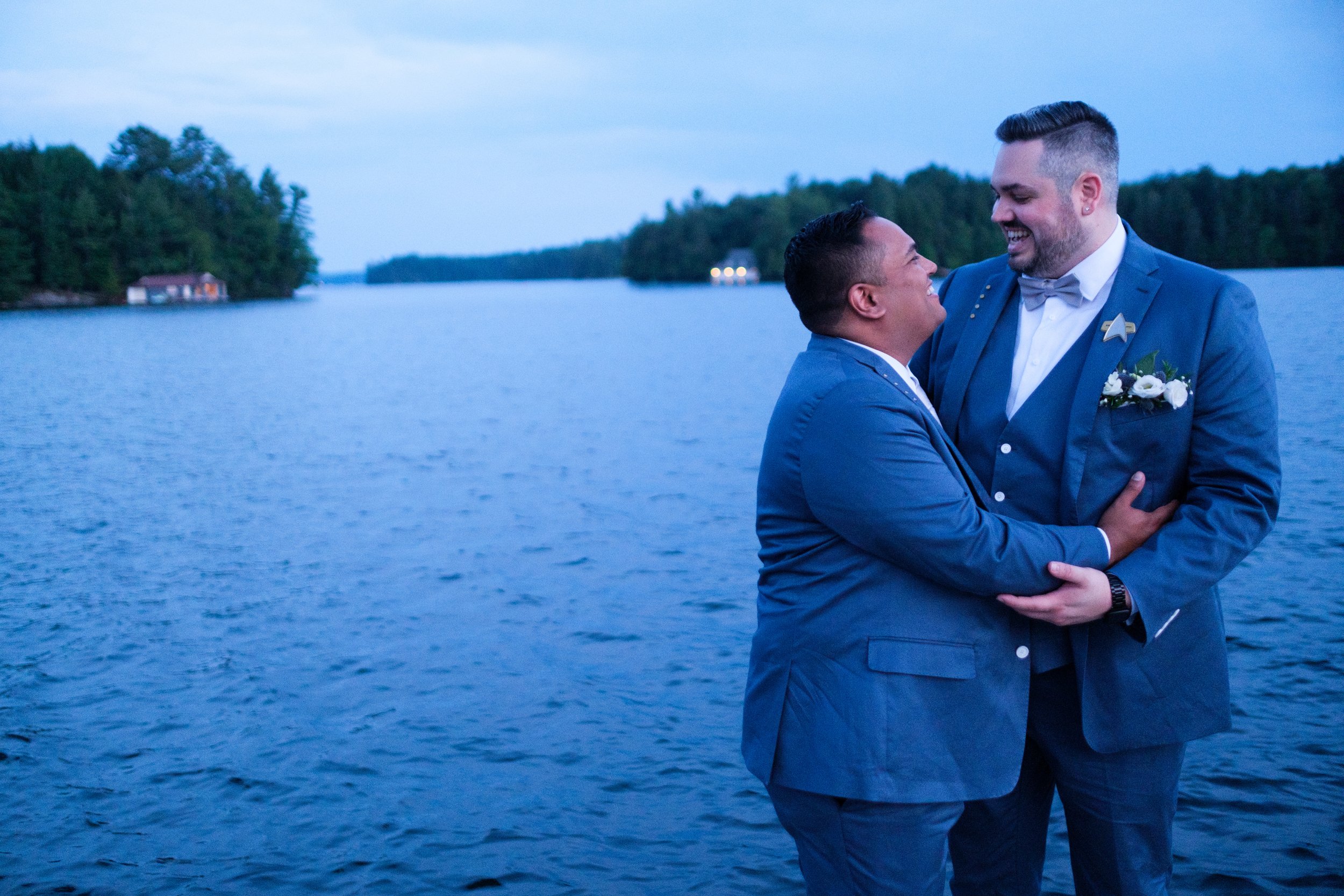  A color wedding portrait photograph taken at sunset on the docks overlooking Lake Rosseau of  Bryan + Adam during their wedding reception at the JW Marriot The Rosseau in Muskoka by Toronto wedding photographer Scott Williams (www.scottwilliamsphoto