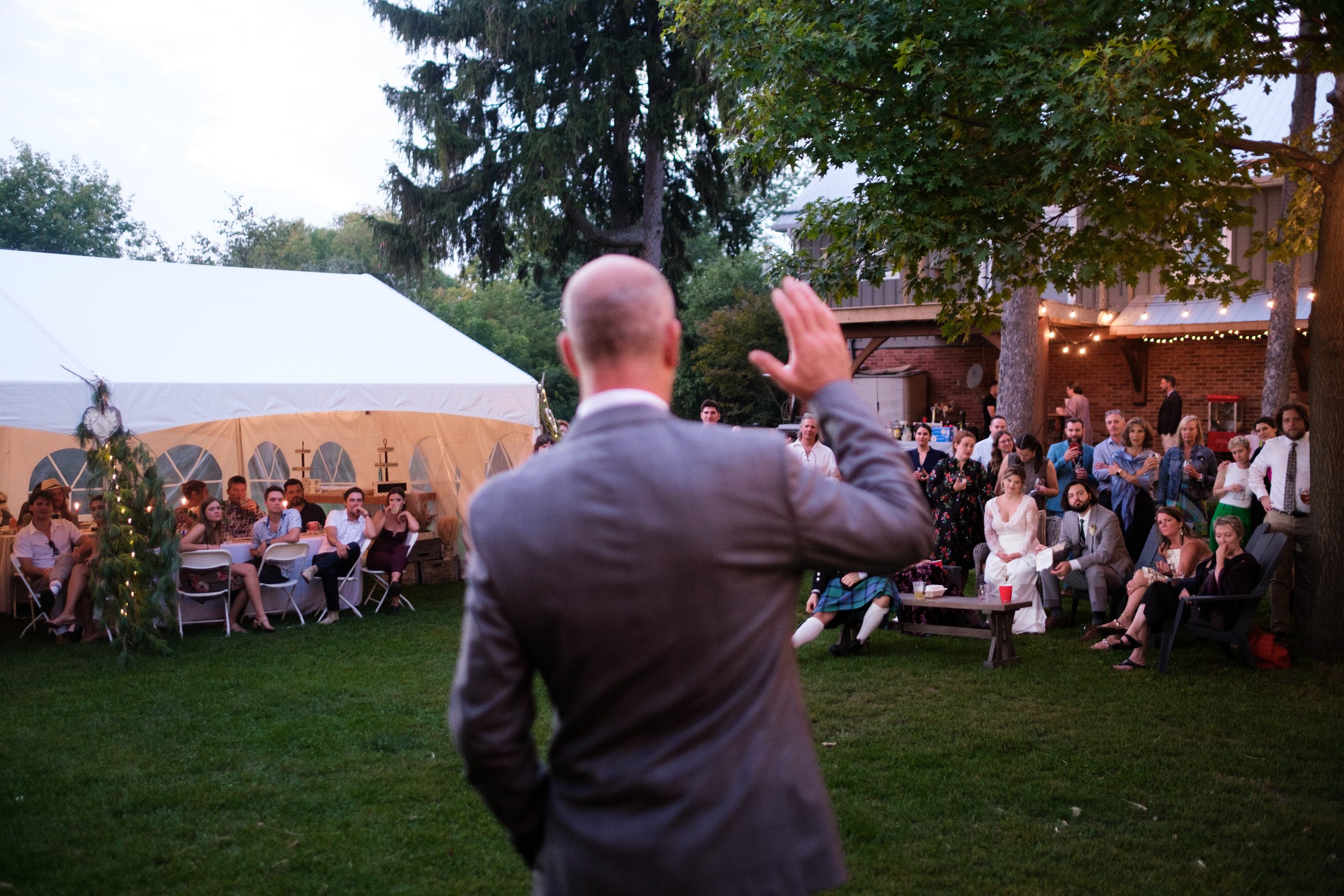  A colour candid wedding photograph of a speech during Ailish + Evan’s outdoor farm wedding near Pickering, Ontario by Toronto wedding photographer Scott Williams  