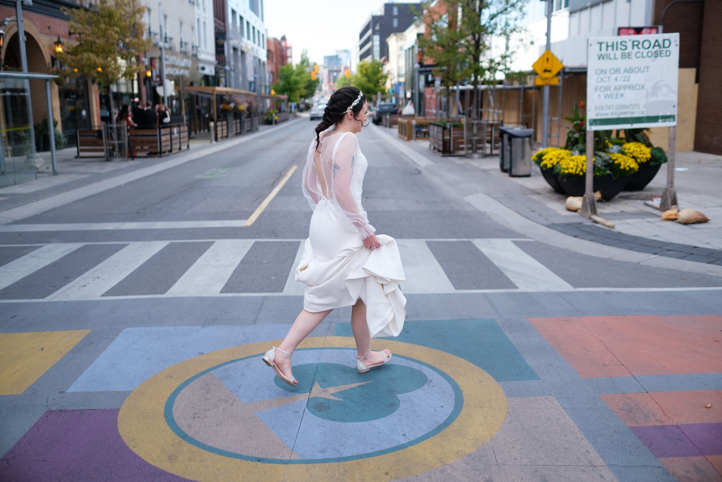  A candid color wedding photograph from Megan + Josh’s Kitchener wedding at The Museum.  The bride is leaving the Walper Hotel and crossing the street for her first look before her wedding ceremony by Toronto Wedding photographer Scott Williams (www.