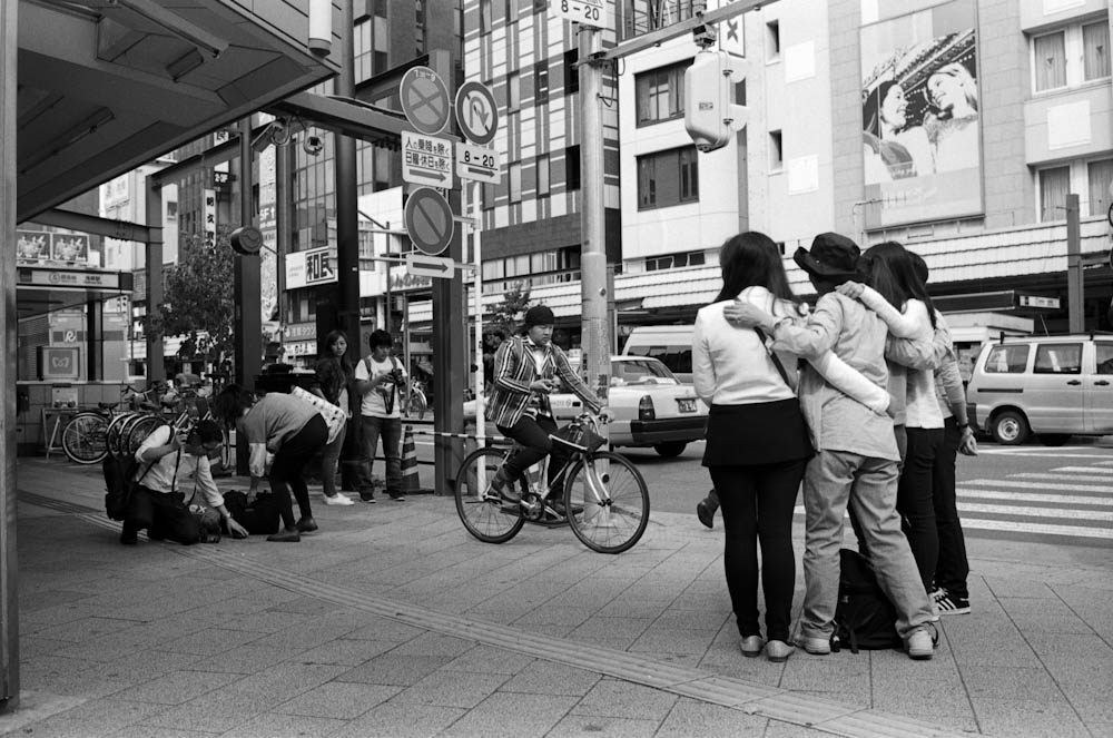 Asakusa, Tokyo - the person in the middle of the frame is riding their bicycle and using their cellphone at the same time. People in Japan ride their bicycles... a lot.