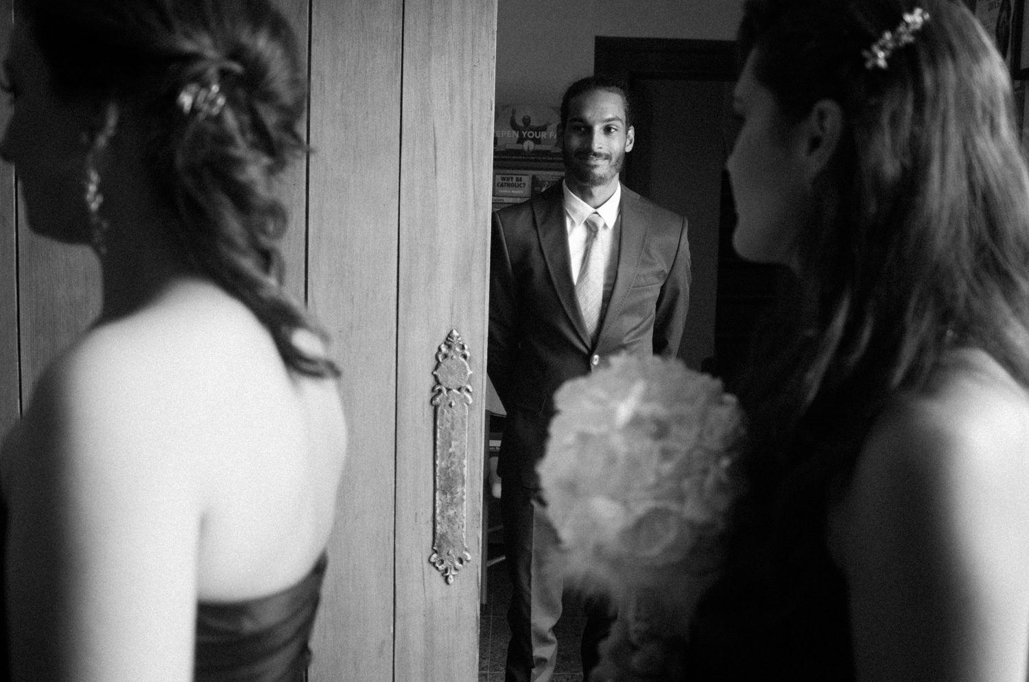I was actually holding the door with this gentleman while the bridesmaids were making their way down the aisle. One foot (or hand?) on the door and the other hands on my camera trying to get this moment composed properly. In the end, it worked out and the bride and bridesmaid were able to make their way up the aisle.
