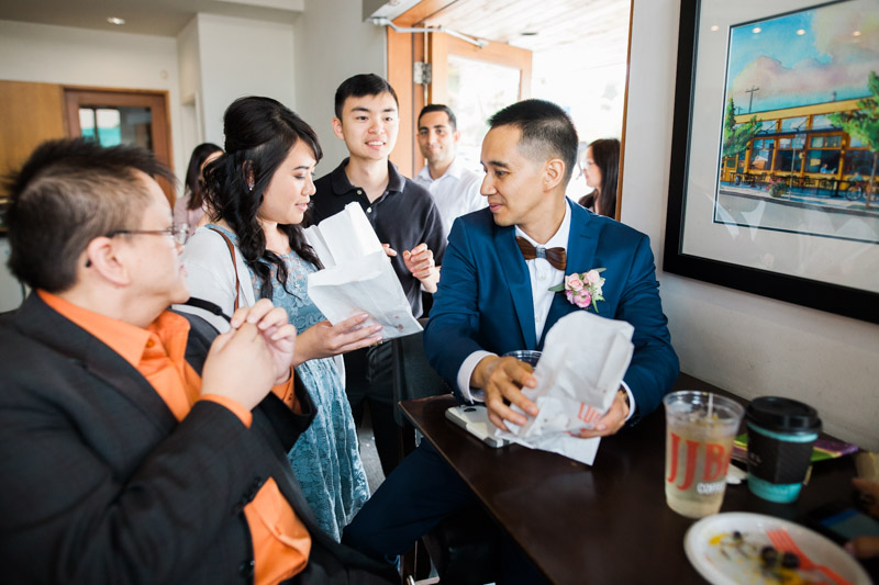 Even when big "things" aren't happening on a wedding day, I love to photograph the in-between moments like this. Here, a few friends of Jesse and Patricia bring donuts from 49th and Parallel to munch on while they rest at JJ Bean (so much "Main Street" going on in that sentence!!).