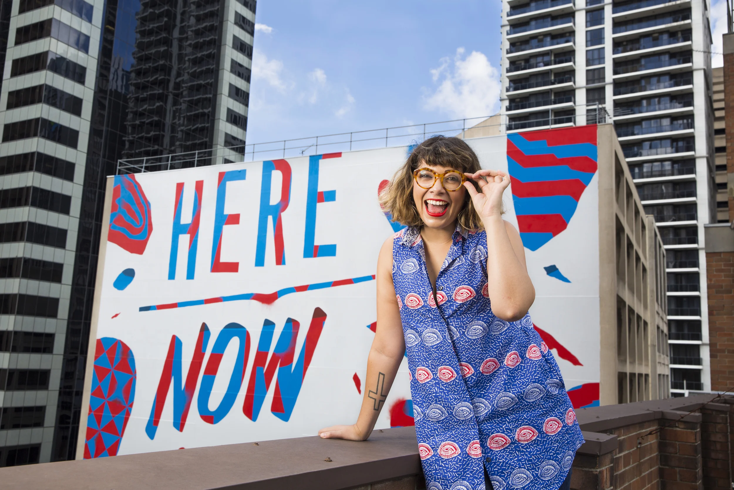 Jess Scully in front of Elliot Numskull's 'Here, Now' mural