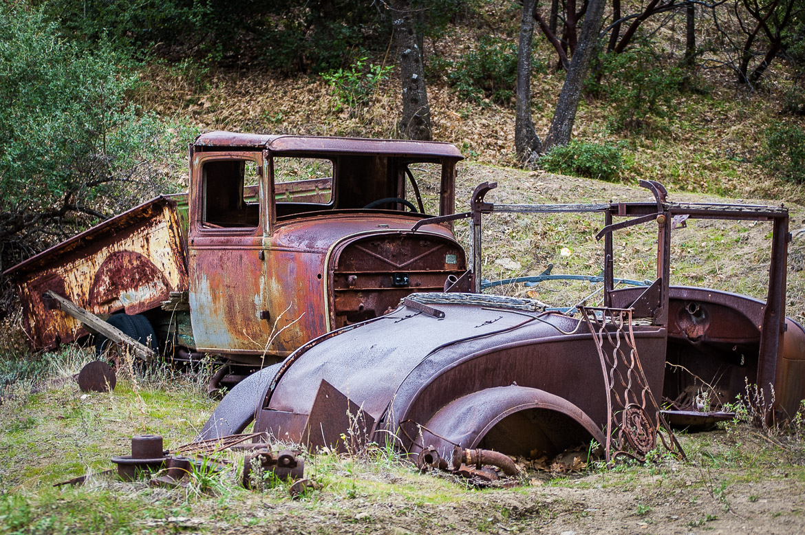 The earth swallows what remains of these old car bodies near Eagle Mine in Julian, California.