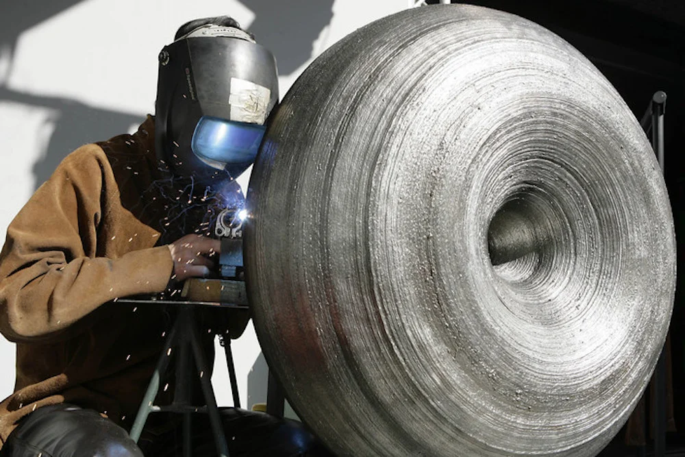 Weldgrown Year : 2009 Material : stainless steel Dimensions : 1000 x 400 x 400 mm Awards : Nominated for the Dutch Design Awards 2009 / Autonomous Design Category Private Collection Description : In 2009, Tomáš was approached by Ambra Medda (co-founder of Design Miami and founder of L'ArcoBaleno) and her team to participate in Craft/Punk event commissioned by FENDI fashion house. The main theme was craft. Studio Libertiny undertook to explore the craft of welding in a production of time consuming production process. The semi-robotic system was devised to craft an object of multitudes of layers of welded stainless steel. The result was a light and extremely strong form in a shape of a void. Texture of erratic nature was in strong contradiction to the shape, industrial vs. natural.