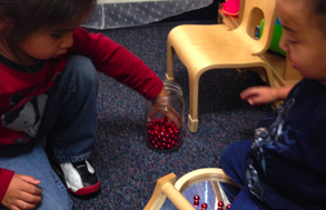 Elias and Dallas add more beads to the curved mirror. They took great delight in taking turns rocking the beads back and forth
