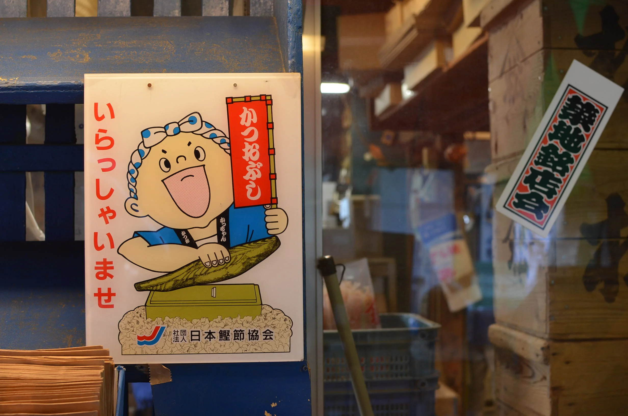 Sign in Tsukiji fish market depicting a chef shaving katsuobushi.