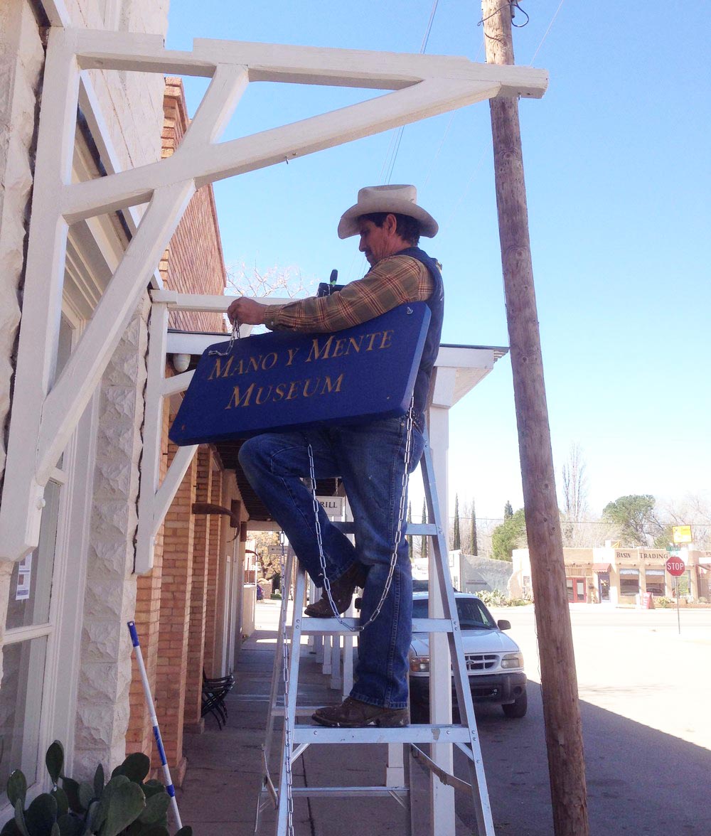 Hanging the Mano y Mente Museum sign in historic downtown Tularosa, NM.