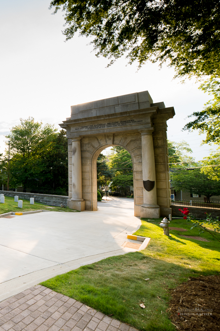 A granite memorial arch at the cemetery gate is inscribed: "Here rest the remains of 10,312 Officers and Soldiers who died in defense of the Union 1861-1865." 