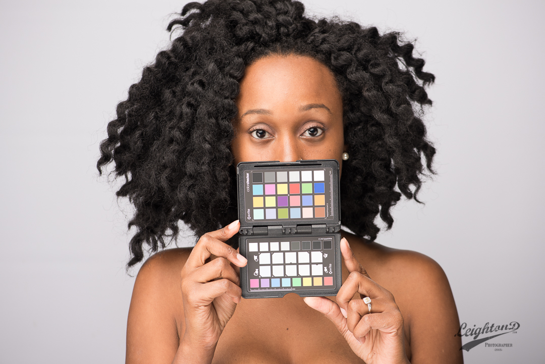 Unedited: Model, Aquisha G. holds up a color checker for establishing a color reference.
