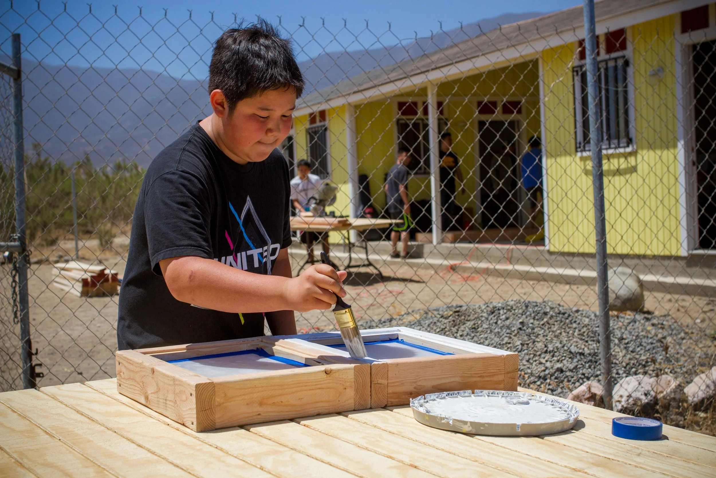 One of the exciting projects we took was building up an outhouse from scratch! As you can see here, Daniel is painting the windows.
