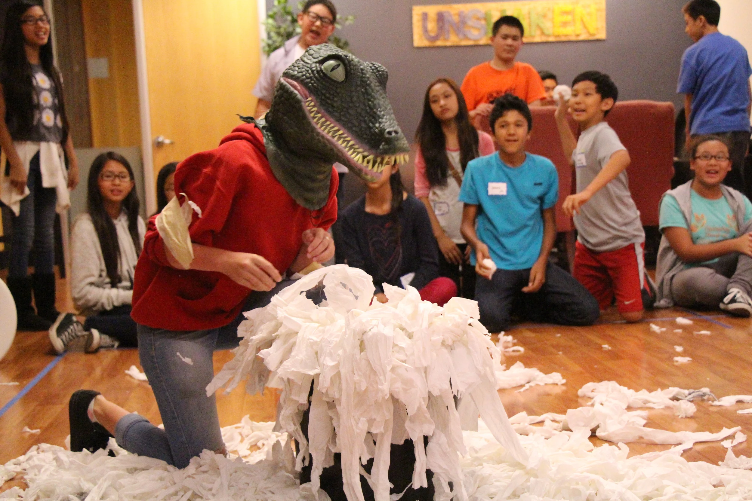 And of course, our game masters were genius enough to invent a game that involved cleaning up too! Students donned dinosaur masks and competed to see which team could pick up the most toilet paper with their wrists bound together by masking tape. It was surprisingly challenging, and makes me wonder how T-rexes could become predators when they couldn't even pick things up.