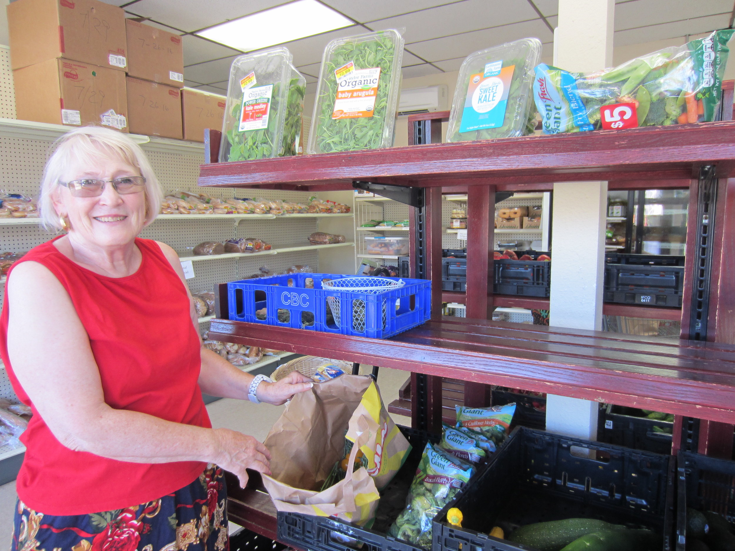 Lynda, a St Johns Food Share member and volunteer, shows off available options at the store.&nbsp;