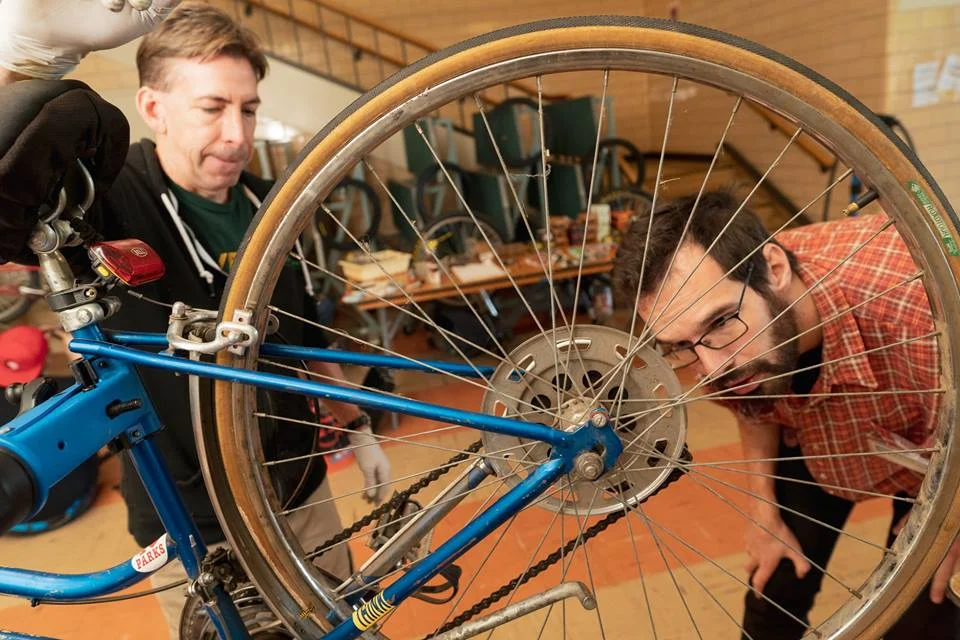 Joel (right) fixing a bike at a Repair Cafe.