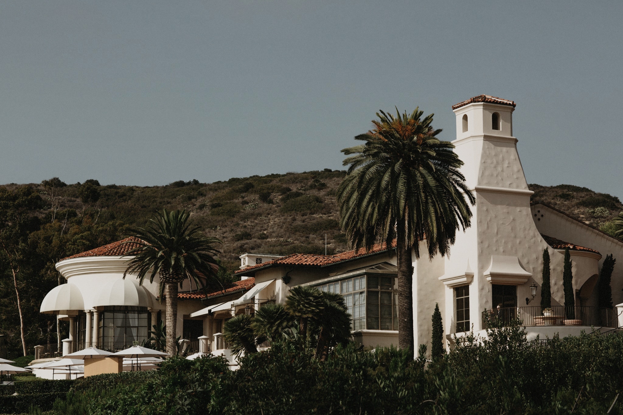 Palm trees stand before the Resort at Pelican Hill, a stunning wedding venue in Orange County.