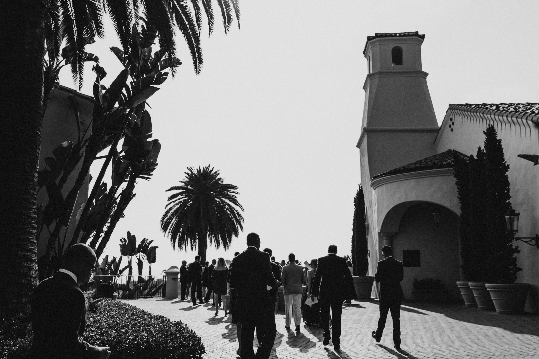 Guests walk outside of The Resort at Pelican Hill, preparing for a beautiful wedding ceremony in Newport Beach.