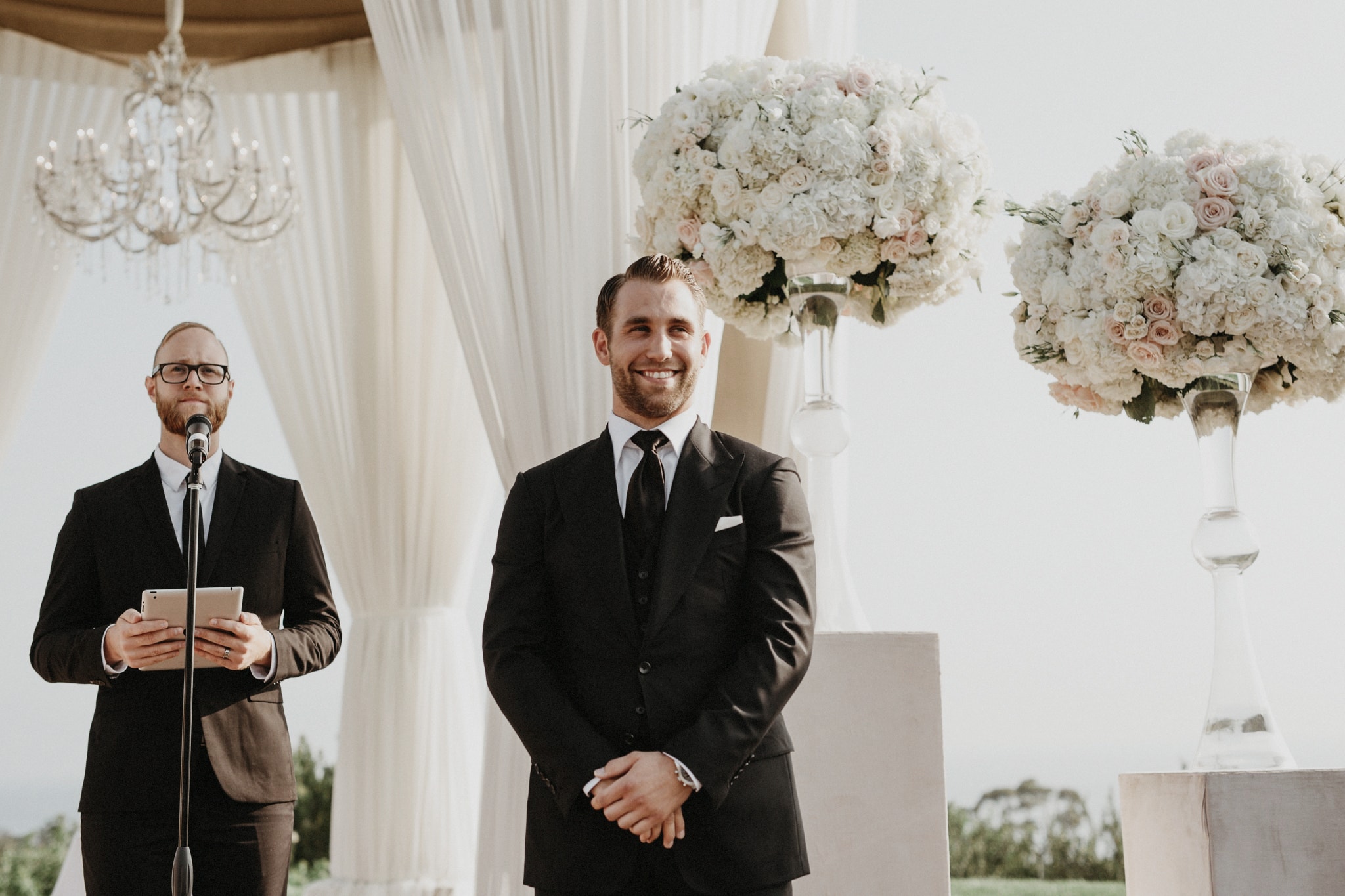 Josh Olson wedding photographer captures a handsome groom smiles at the alter at a beautiful outdoor wedding ceremony in Newport Beach, California.