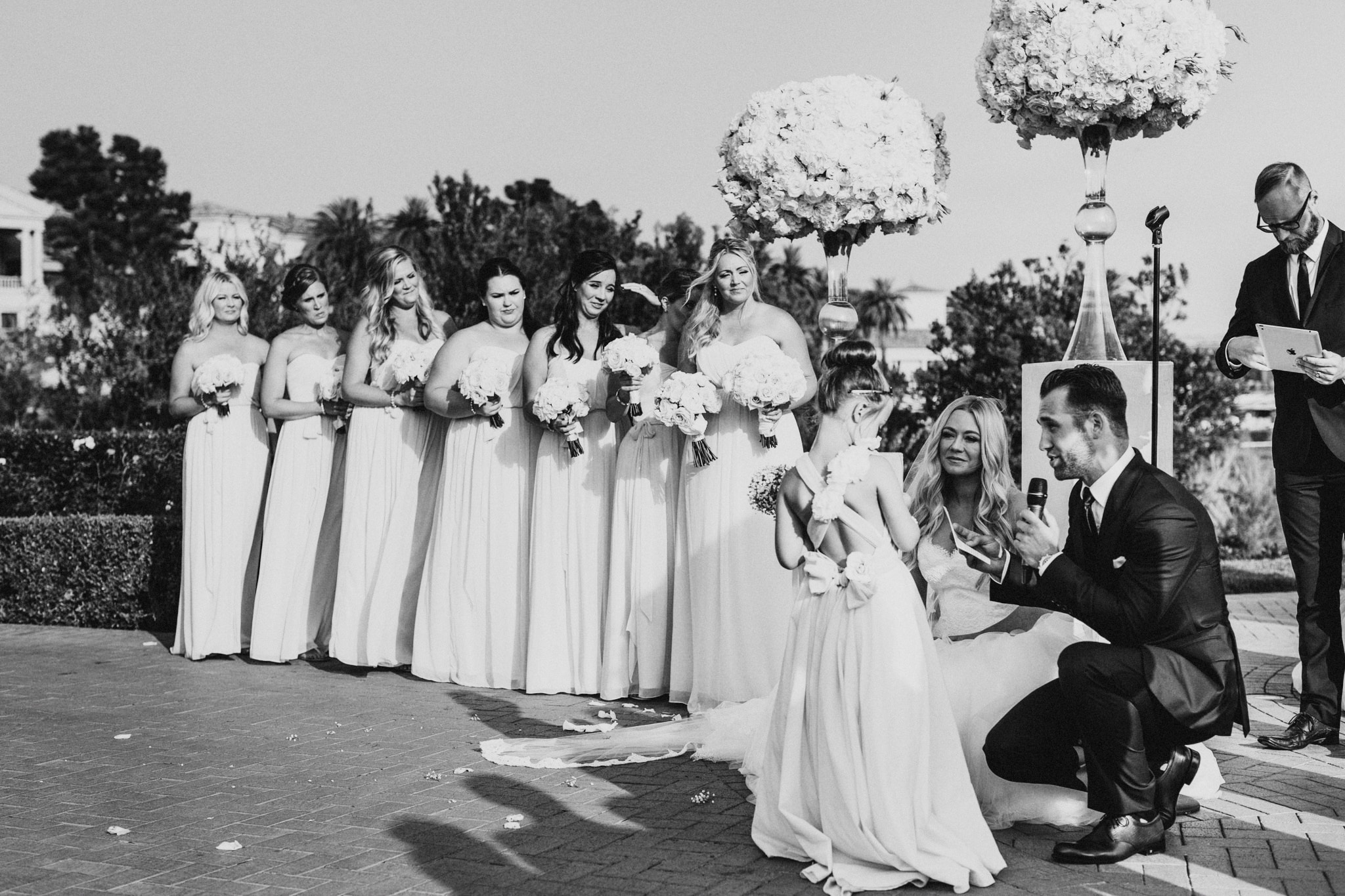 A bride and groom speak to the flower girl during a beautiful wedding ceremony at Pelican Hill Resort on Newport Beach.