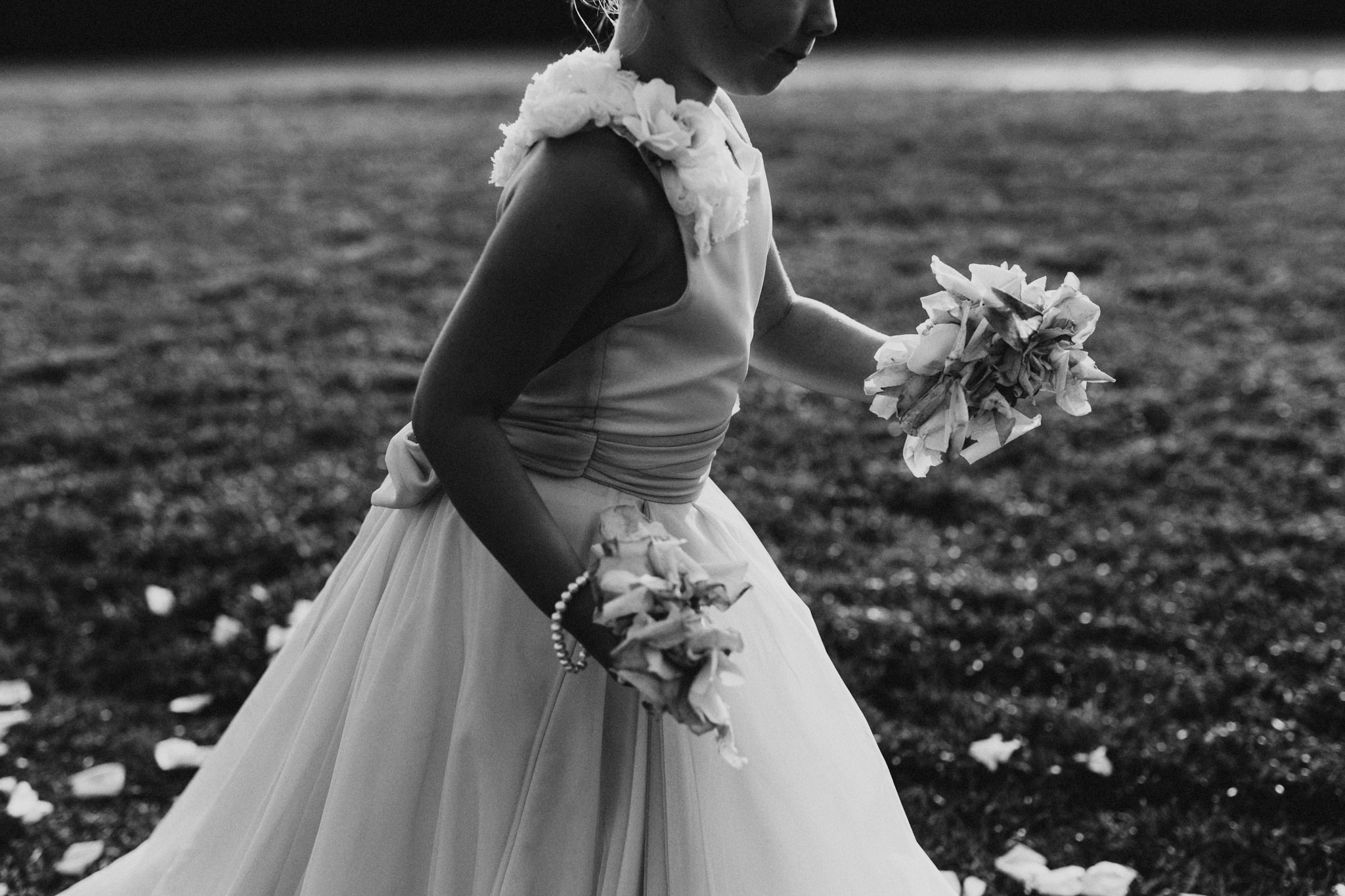 A flower girls runs with petals in her hands during a California wedding, moment caught by Josh Olson wedding photographer.