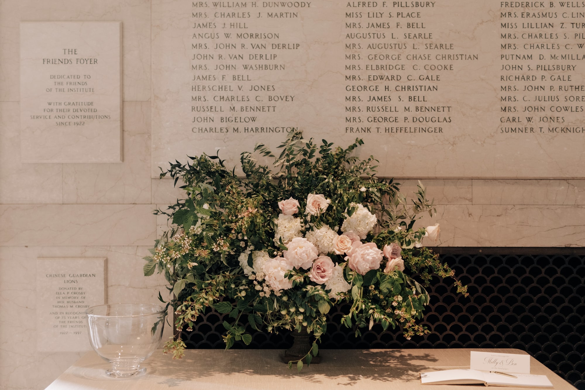 A beautiful bouquet of blush pink flowers and green foliage sits on a table at a wedding at the Minneapolis Institute of Art.