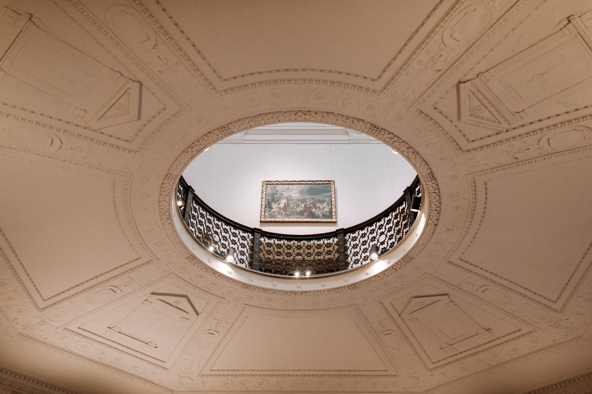 A hole in the ceiling of the lower level of the Minneapolis Institute of Art looks up to a balcony on the upper level.