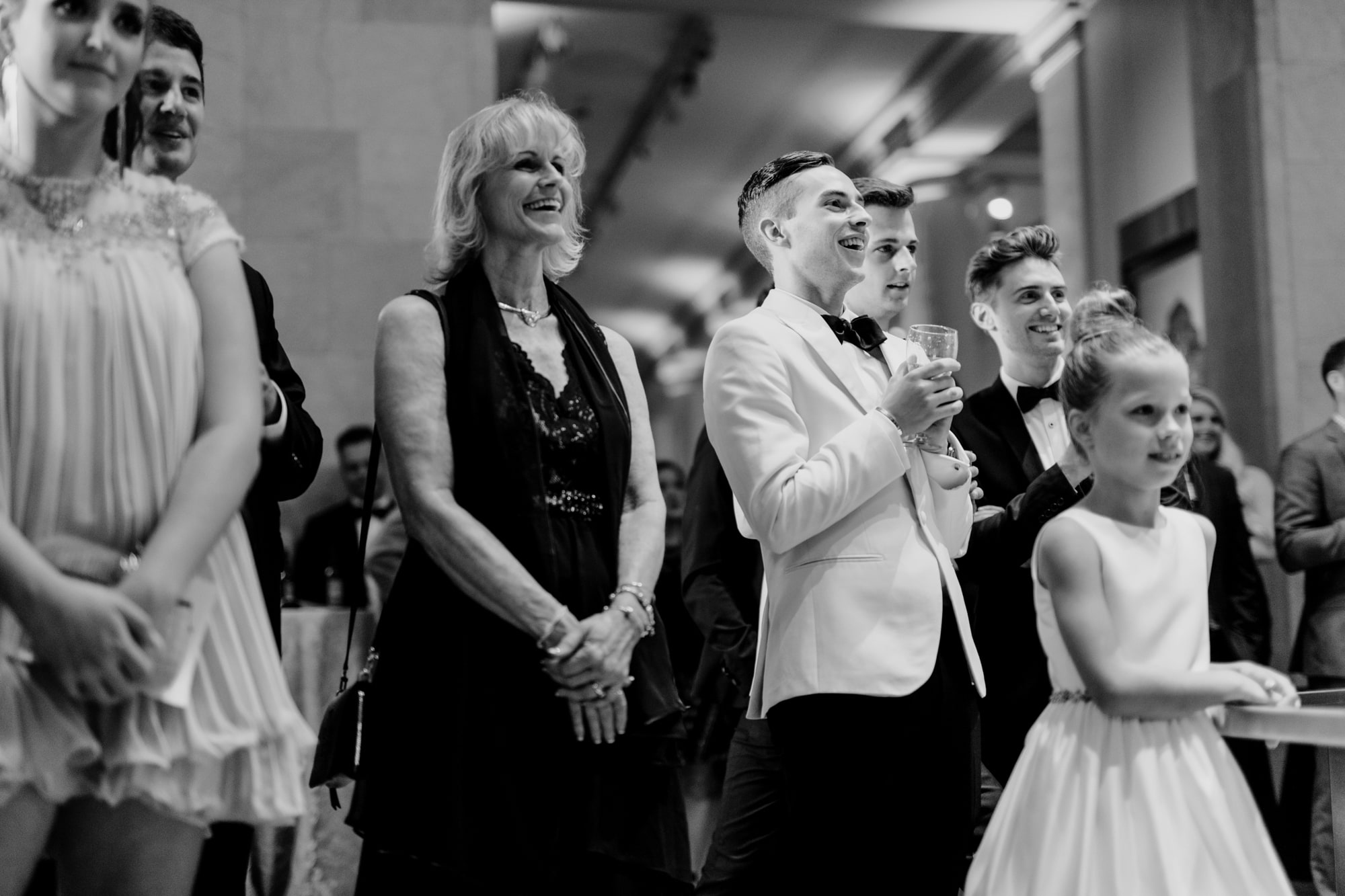 Guests smile while listening to speeches during a wedding at the Minneapolis Institute of Art.