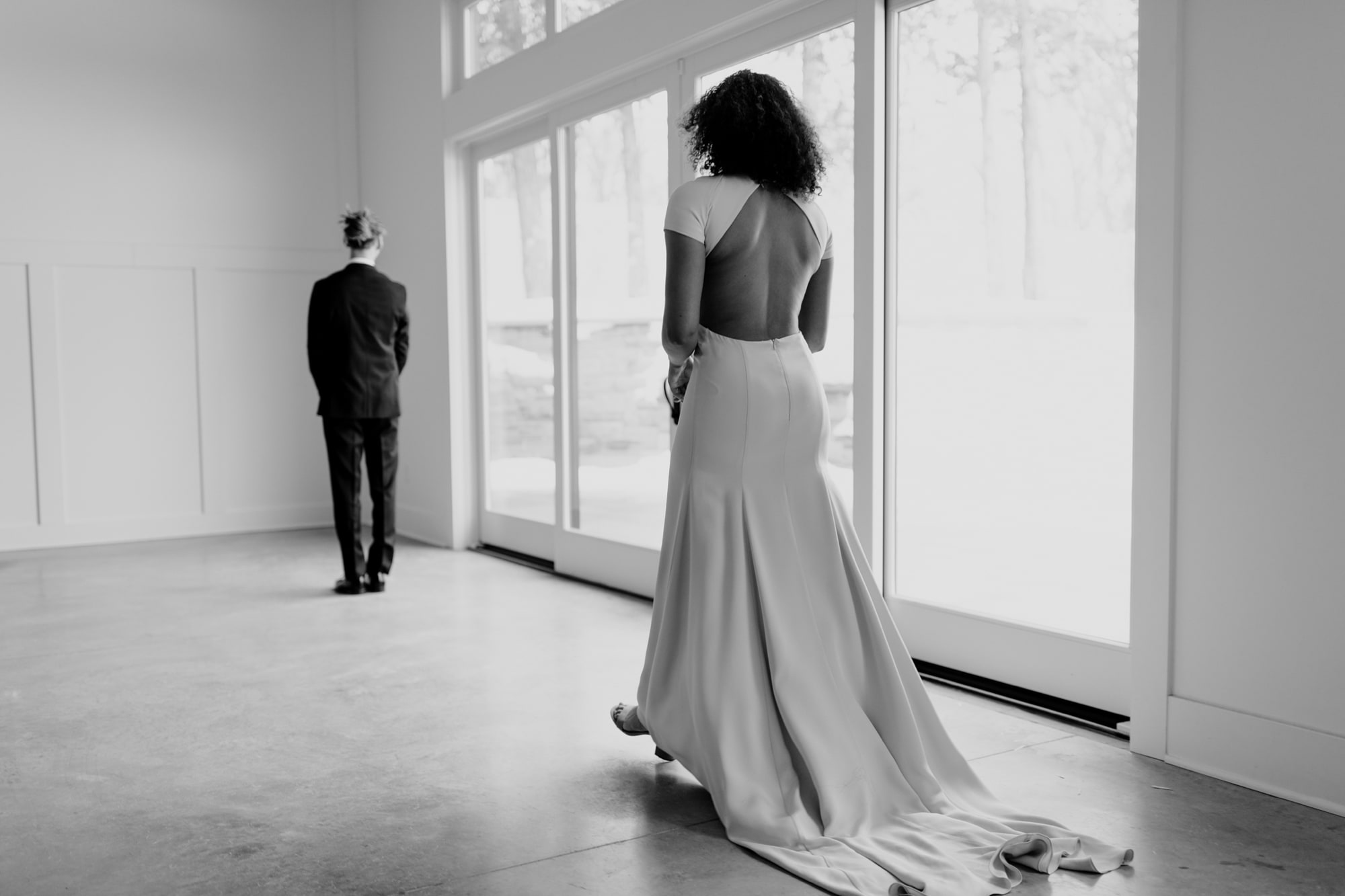 A bride in a beautiful backless dress walks towards her groom for a first look in Minneapolis.