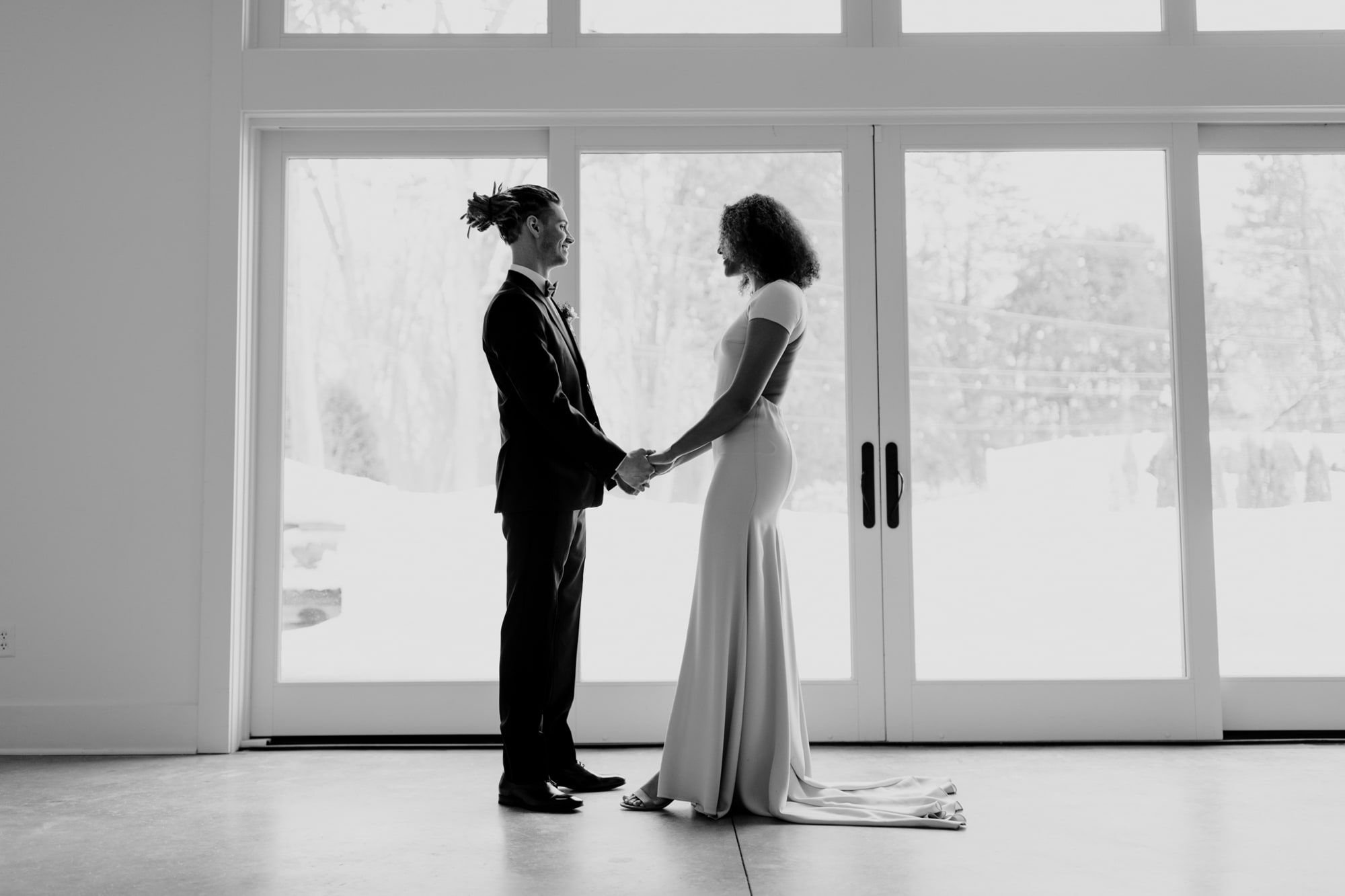 A bride and groom look at each other while holding hands during a wedding photoshoot with j.olson weddings in Minneapolis.