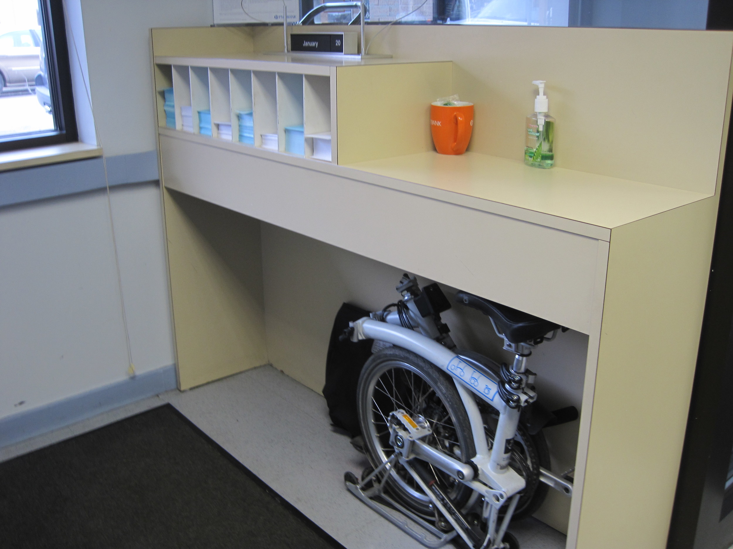 Our bank has a perfect parking spot for our Brompton right underneath the deposit/withdraw slip counter.