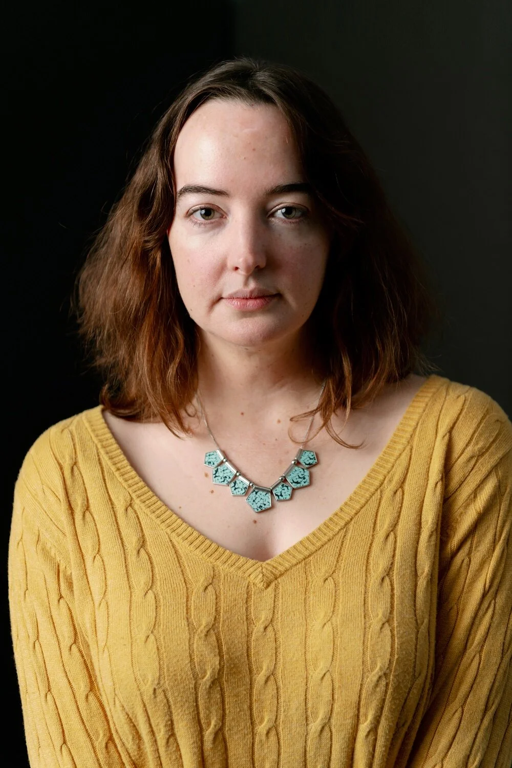 Professional portrait with subtle smile on gray seamless background
