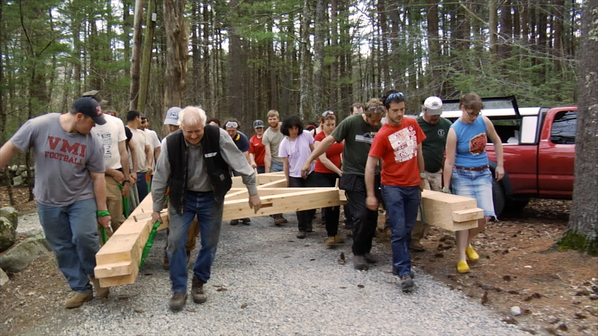 Still 8: Rick Brown leads a group of timber framers (students and professionals) to the final site of the Polish bell tower.