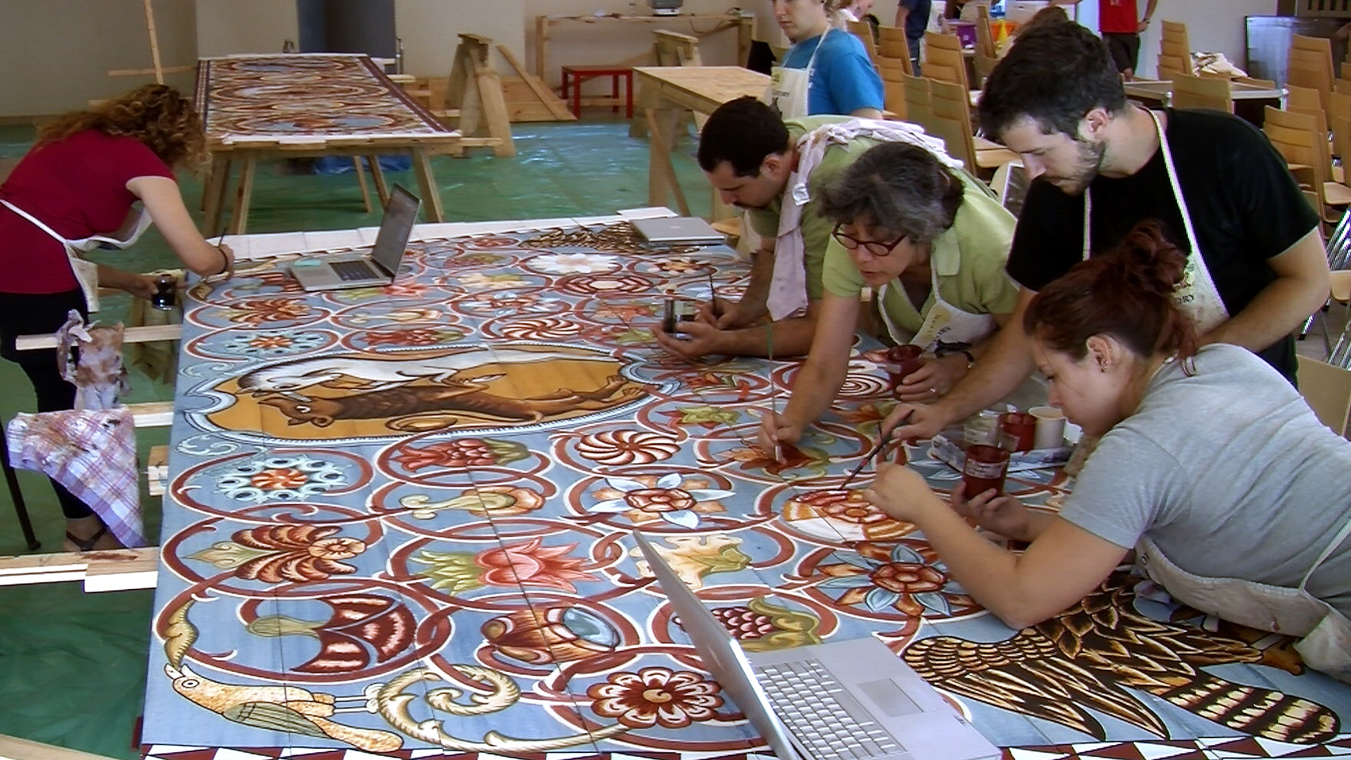 Still 21: Painting leaders and students working together to complete flowers on the north dome panel.