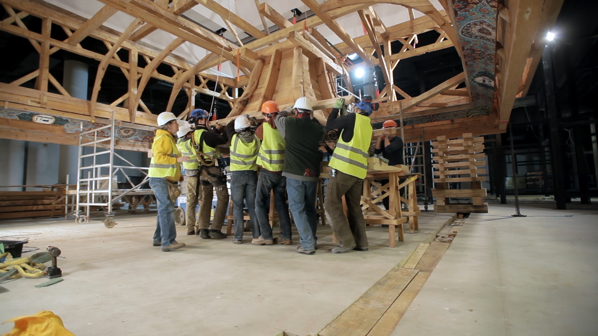 Still 40: The timber frame crew lift the lantern onto a platform before hoisting it into place in the roof.