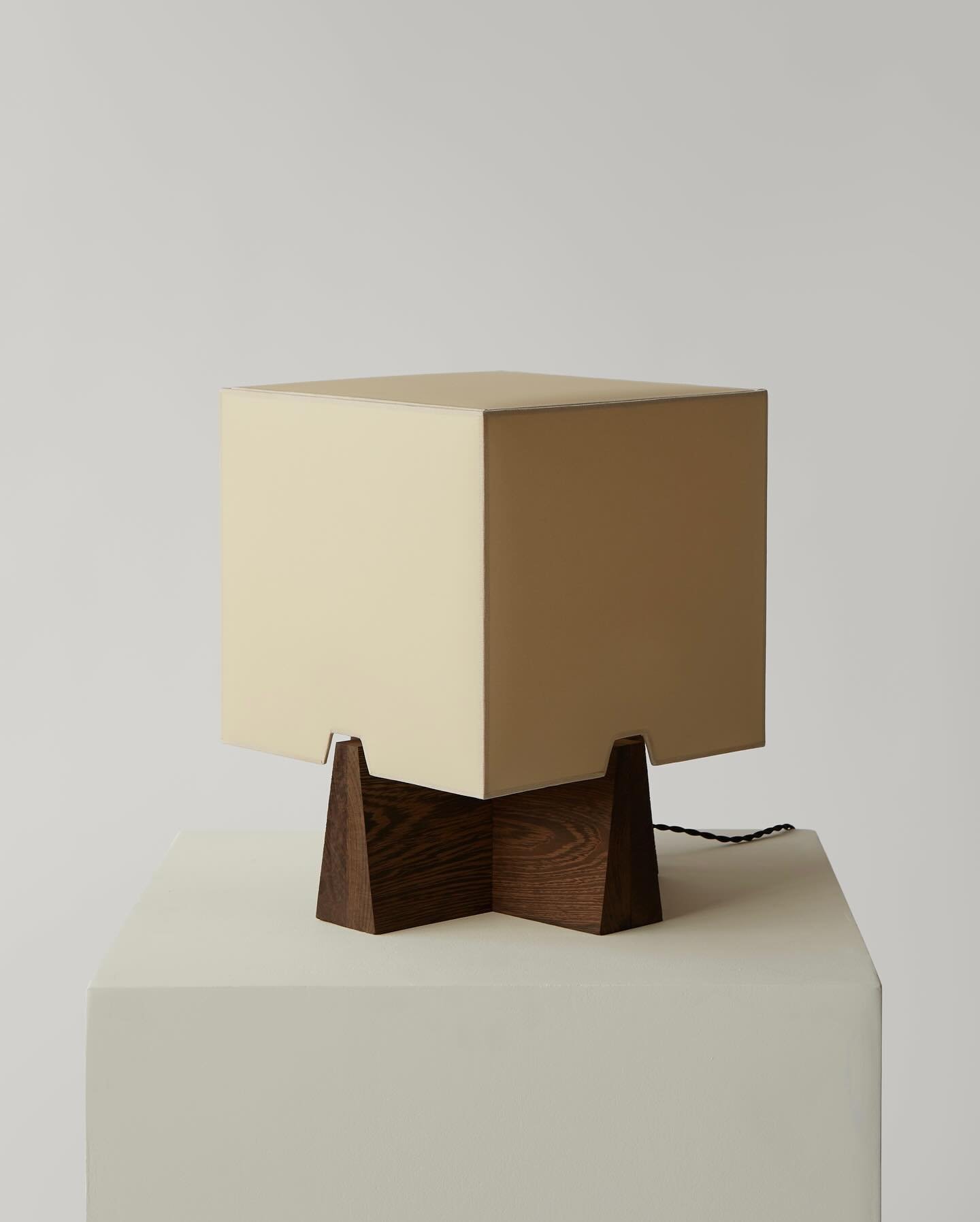 the Lucie table lamp 💡 made by hand in New York from tapered solid wood intersecting a cube shade in european vellum. Shown here sampled in a custom Wenge base, available in oxidized white oak or bleached ash