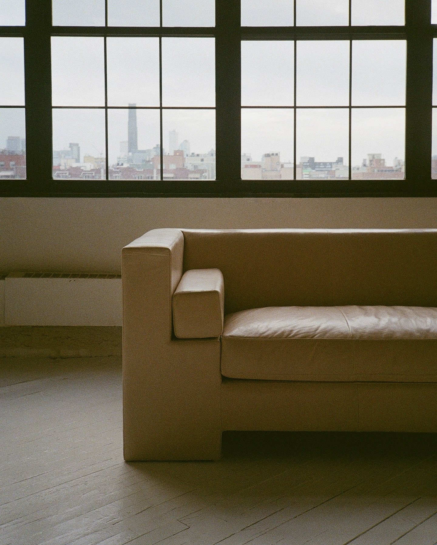the Milo sofa, with topstitched square cushions, shown upholstered in Italian leather