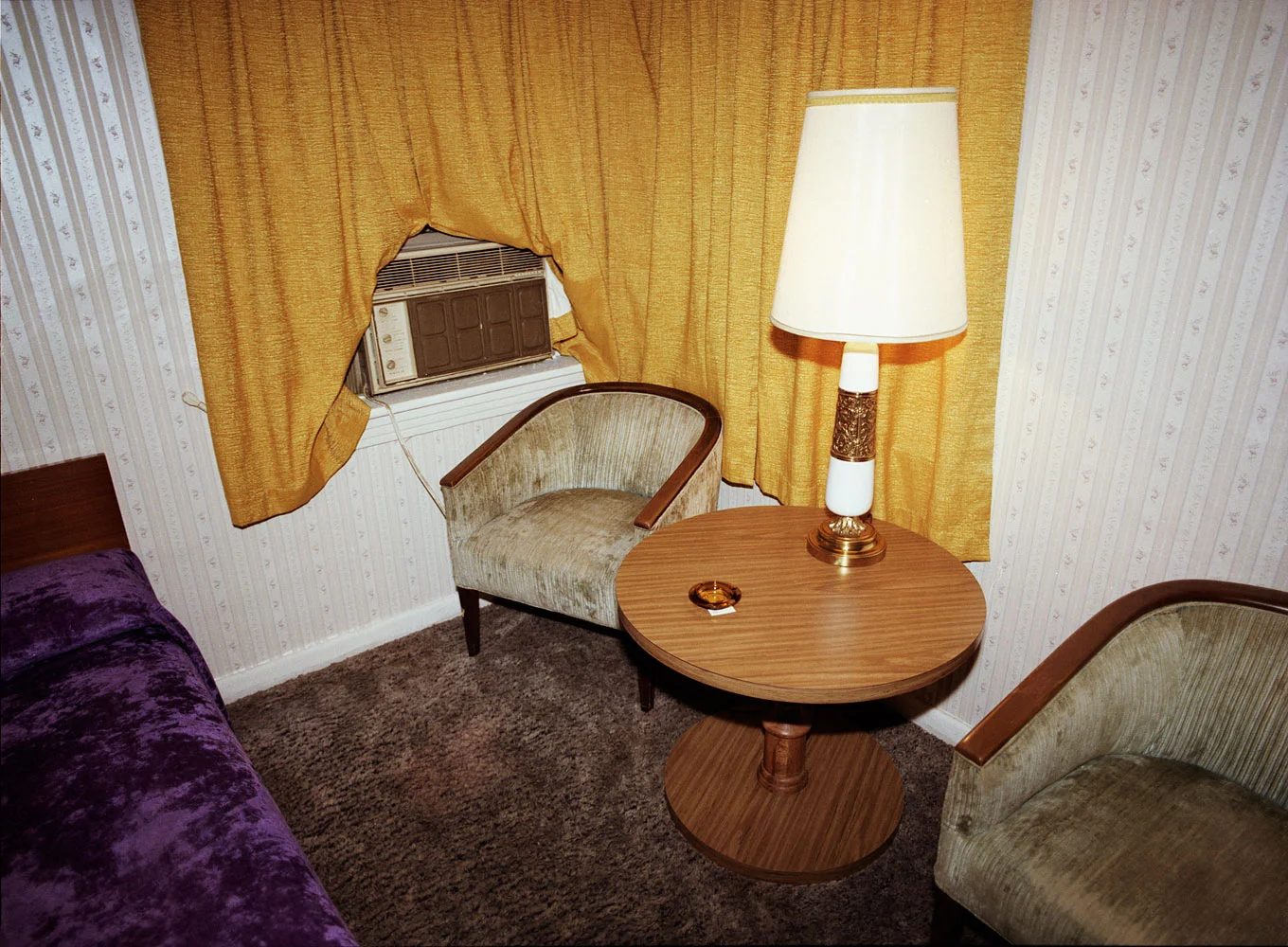 Motel room with green plush chairs