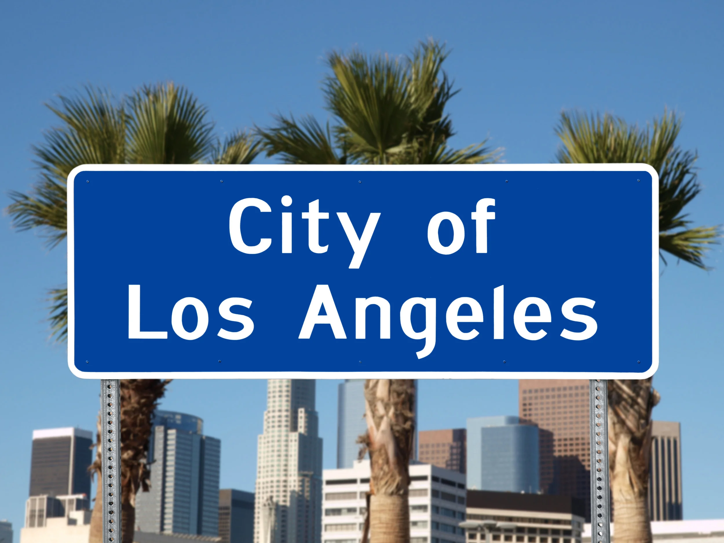 Los Angeles city limit sign with towers and Palm Trees.jpg